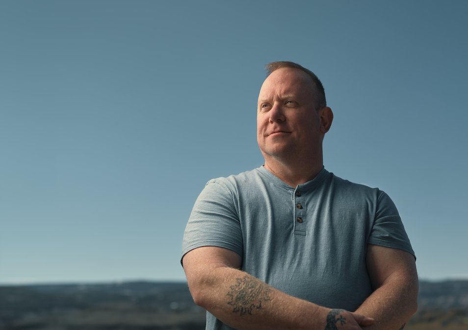 Man with arms crossed looking off into the distance